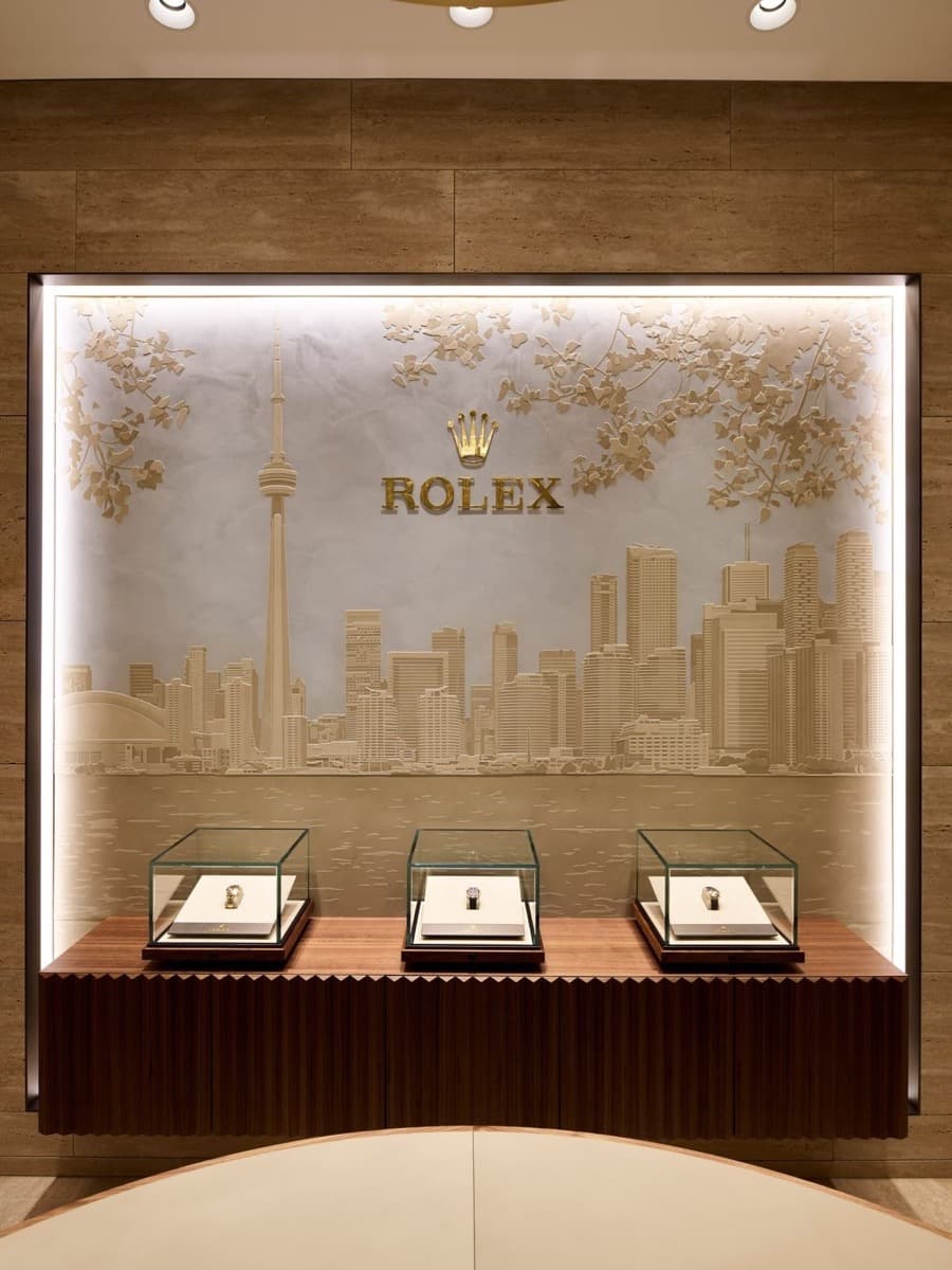 A watch retailer’s display wall with three lit vitrines